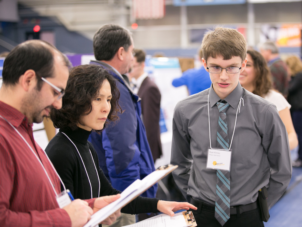 A participant interacting with judges at the Maine State Science Fair