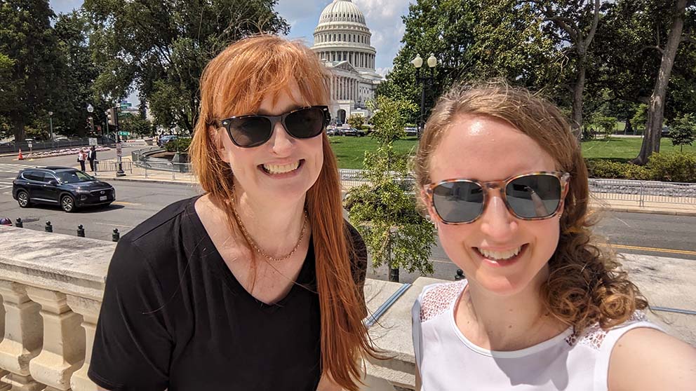 Jill Homer Stewart (left) and Christina Vallianatos (right) snap a photo in front of the capitol building on their way to the Fair.