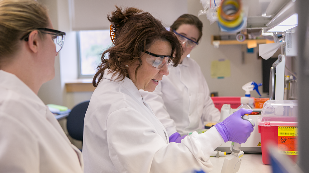 Cat Lutz (center) working in her lab at The Jackson Laboratory. Photo credit: Aaron Boothroyd